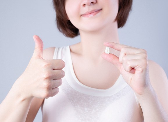a patient giving a thumbs up after tooth extraction