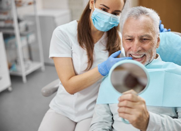 Dental assistant smiling while handing patient form