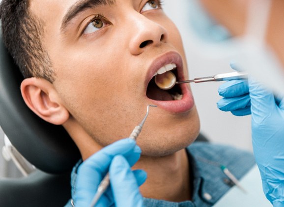 Patient looking at reflection with smiling dental assistant