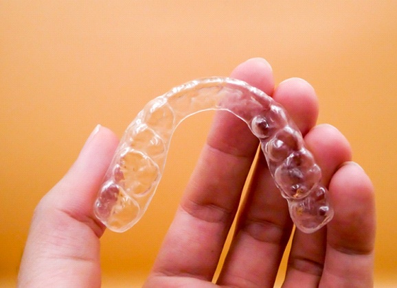 person holding an Invisalign tray